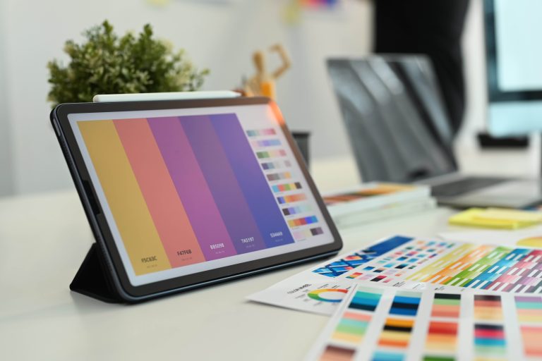 Creative designer, Graphic at workspace with digital tablet, color swatch samples and stationery on wooden table